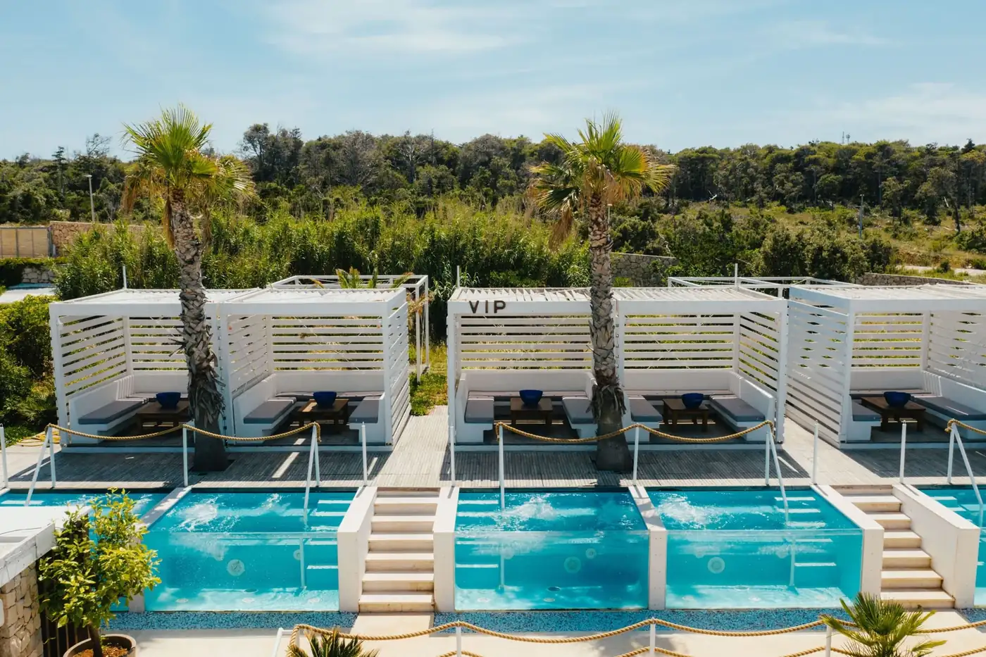 Nomad Beach Club private jacuzzi cabanas and palm trees at Zrće Beach